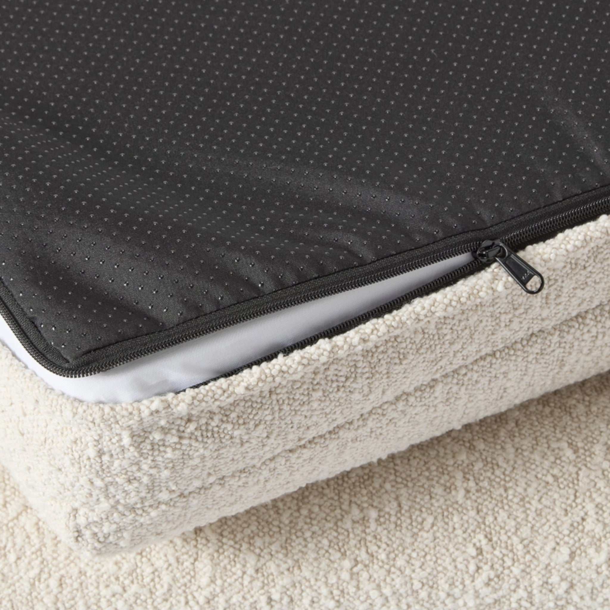 Close-up of the washable boucle cover and zippered memory foam mattress of the Hundebett Barklay S dog bed with non-slip backing