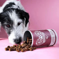 Bild in Galerie-Betrachter laden, Dog enjoying Tierliebhaber Chillout Drops for calming and relaxation, with natural ingredients like valerian, St. John's wort, and lavender, in a pink background setting.